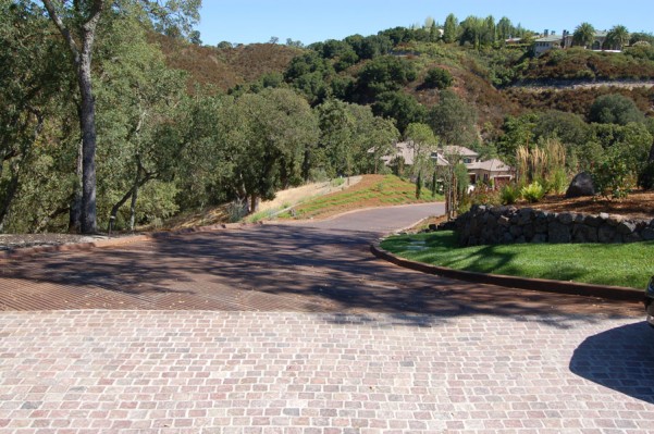 Edge of Finished driveway featuring a running bond pattern in Copper Mountain Porphyry as it meets the main road